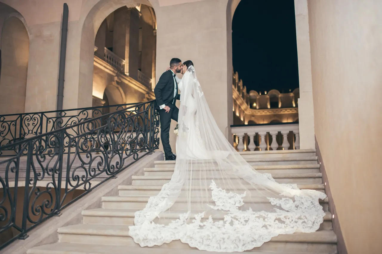 Mariée à très longue traîne sur l’escalier d’un château, Studio Bena
